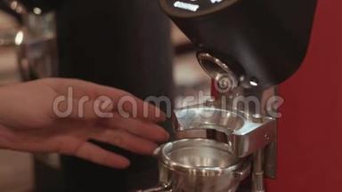 咖啡<strong>吧台</strong>后面的咖啡研磨机把磨碎的咖啡倒在支架上，女<strong>酒吧</strong>手把它拿走了。 Baristas肖像